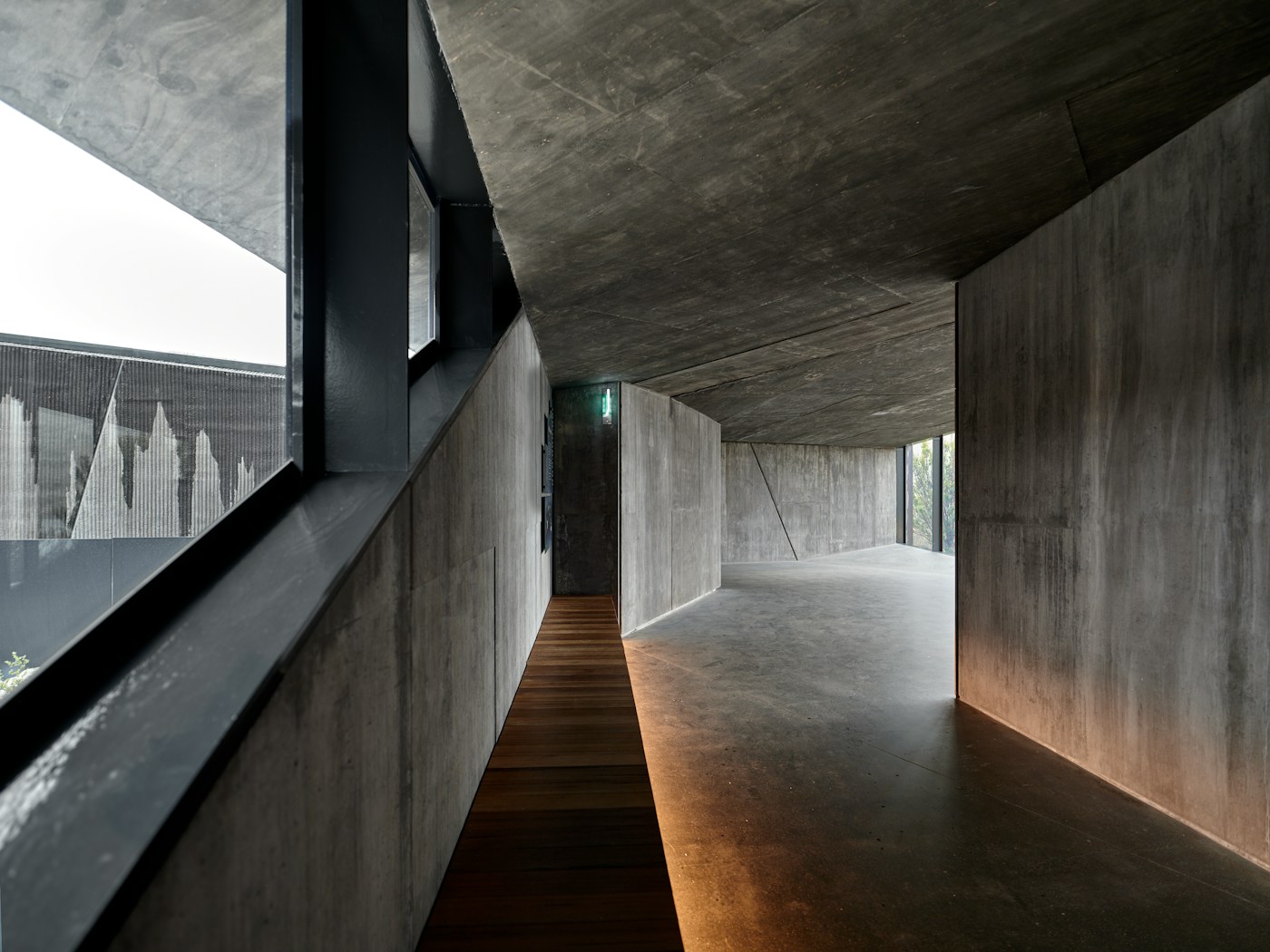 Long Corridor — a raw concrete and blackbutt hallway threading a Bardon home